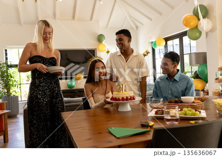 Celebrating birthday, friends smiling and enjoying cake at home party 135636067