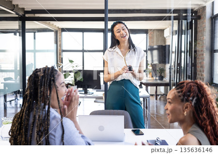 Leading meeting, businesswoman with colleagues discussing ideas in modern office setting 135636146