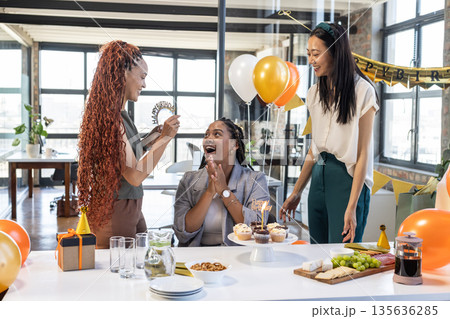 Celebrating birthday in office, colleagues sharing cupcakes and balloons, enjoying moments 135636285