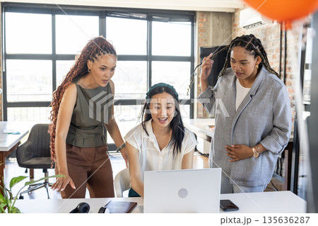 In office, diverse businesswomen discussing project results and celebrating success together In office, diverse businesswomen discussing project results and celebrating success together 135636287