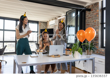 Celebrating success, diverse colleagues clapping and smiling with cupcakes in office 135636337