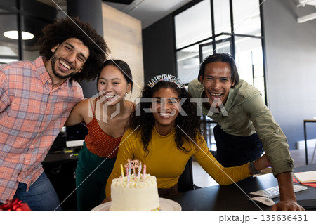 In office, colleagues gathering around cake, celebrating birthday with decorations 135636431