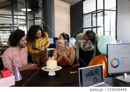 Celebrating birthday, colleagues sharing cake and balloons in office, joyful moments 135636440