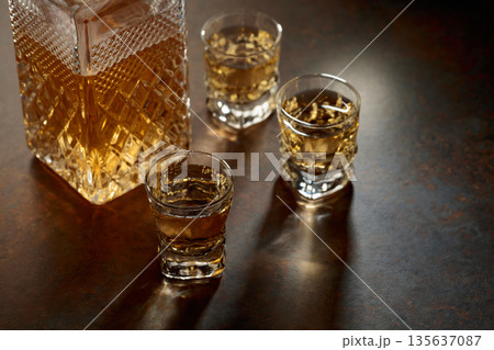 Decanter and small glasses of whiskey. 135637087