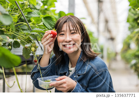 笑顔でいちごを持つ女性 笑顔でいちごを持つ女性 135637771