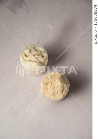 Protein powder in scoops. Body building, muscle growth and food supplement concept Protein powder in scoops. Body building, muscle growth and food supplement concept 135638274