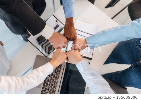 Fists to fists gesture. Top view of hands of business people that are celebrating success Fists to fists gesture. Top view of hands of business people that are celebrating success 135638606