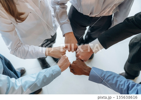 Fists to fists gesture. Top view of hands of business people that are celebrating success Fists to fists gesture. Top view of hands of business people that are celebrating success 135638616