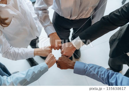 Fists to fists gesture. Top view of hands of business people that are celebrating success Fists to fists gesture. Top view of hands of business people that are celebrating success 135638617