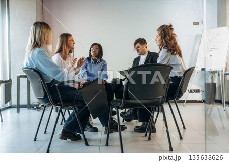 Sitting and talking. People are in group psychological support room together 135638626