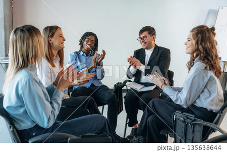 Applauding together. People are in group psychological support room 135638644