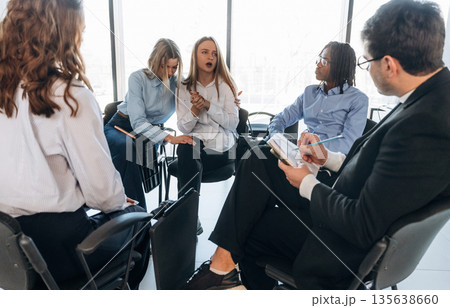 Listening and writing information. People are in group psychological support room together Listening and writing information. People are in group psychological support room together 135638660