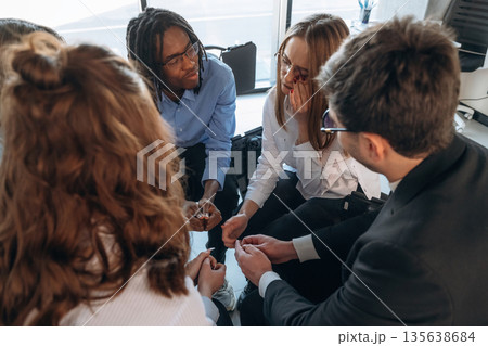 Sad woman is crying. People are in group psychological support room together 135638684