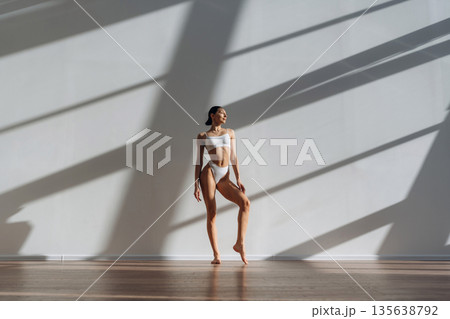 In sportive underwear. Beautiful young woman with slim body type is indoors In sportive underwear. Beautiful young woman with slim body type is indoors 135638792