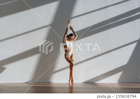Daylight goes into the room. Beautiful young woman with slim body type is indoors 135638794