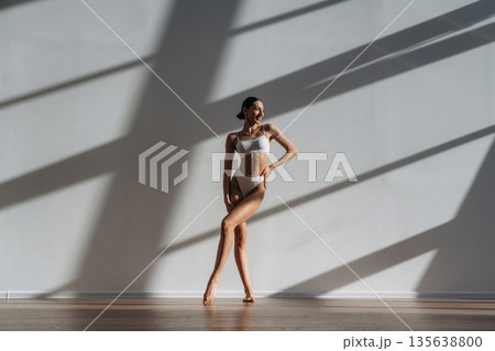 Showing slim body type. Beautiful young woman is indoors Showing slim body type. Beautiful young woman is indoors 135638800
