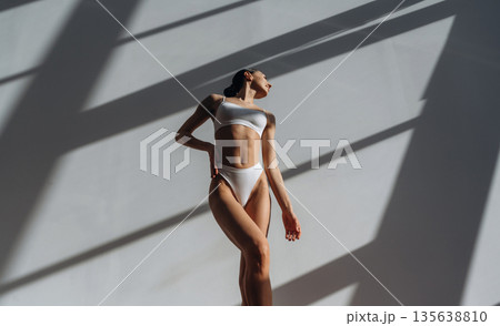 Showing slim body type. Beautiful young woman is indoors Showing slim body type. Beautiful young woman is indoors 135638810