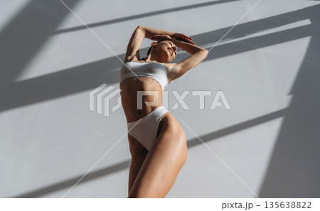 Photo from below. Beautiful young woman with slim body type is indoors Photo from below. Beautiful young woman with slim body type is indoors 135638822