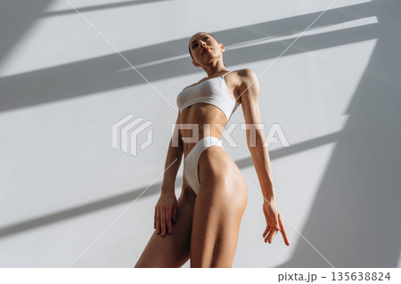 Photo from below. Beautiful young woman with slim body type is indoors 135638824