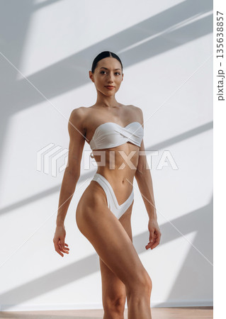 Just relaxing, standing and posing. Beautiful young woman with slim body type is indoors Just relaxing, standing and posing. Beautiful young woman with slim body type is indoors 135638857