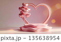 Displaying a wavy pink podium in front of a heart shaped frame with metallic balloons 135638954