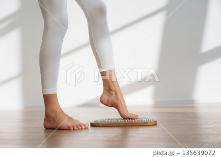 Ready to stand. Close up view of woman's legs that is standing on nails Ready to stand. Close up view of woman's legs that is standing on nails 135639072