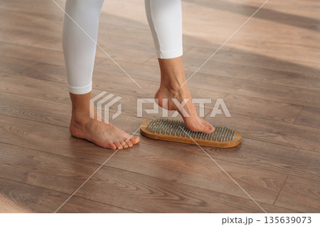 Ready to stand. Close up view of woman's legs that is standing on nails 135639073