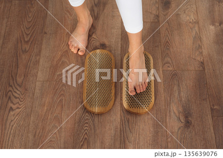 Close up view of woman's legs that is standing on nails 135639076