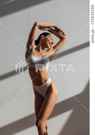 Bright sunlight. Pretty young woman with slim body type is indoors Bright sunlight. Pretty young woman with slim body type is indoors 135639166