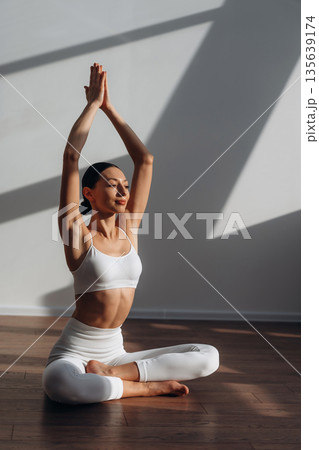 Calm mind, meditation in lotus pose. Beautiful young woman with slim body type is indoors 135639174