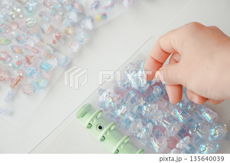 大人気のボンボンドロップシールをシール帳に貼る手元 135640039