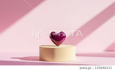 Shiny burnished lilac ceramic heart sits on beige pedestal against pink background with soft shadows 135640231