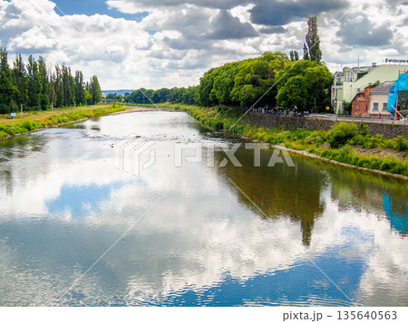 uzhhorod, ukraine - 29 jun, 2007: river uzh on a summer day. uzhhorod city travel background. panoramic view of a historic cityscape with bridge over water. urban landscape of old town in euroope uzhhorod, ukraine - 29 jun, 2007: river uzh on a summer day. uzhhorod city travel background. panoramic view of a historic cityscape with bridge over water. urban landscape of old town in euroope 135640563
