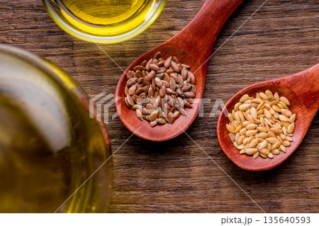 Brown and gold linseed or flaxseed . Healthy flax seed on wooden spoon on wooden table. Top view. 135640593