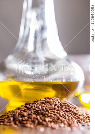 Brown linseed or flaxseed and oil. Healthy flax seed on wooden table. Brown linseed or flaxseed and oil. Healthy flax seed on wooden table. 135640598
