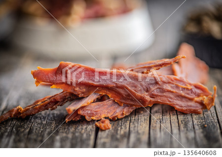 Dog food. Dried meat for dogs on wooden table. 135640608