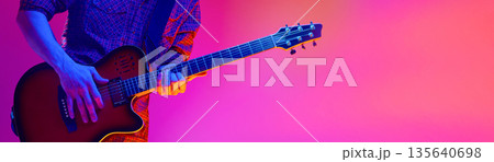 Electric guitar player hands performing on colorful studio background. Banner Electric guitar player hands performing on colorful studio background. Banner 135640698