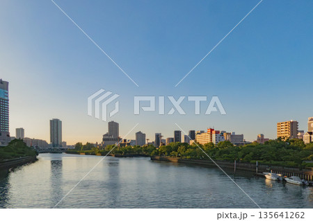 日の出時の広大な川と都市景観 - 落ち着いた背景 日の出時の広大な川と都市景観 - 落ち着いた背景 135641262