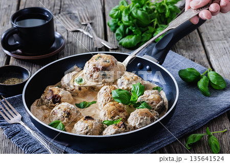 Chicken meatball on spoon over pan with sauce Chicken meatball on spoon over pan with sauce 135641524
