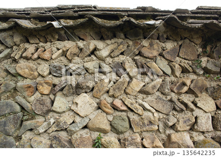 It's a stone wall of a country house. 135642235