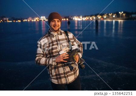 At evening time. A man is on the ice with his skates in winter 135642251