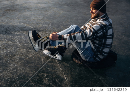 Wearing his skates. A man is on the ice in winter 135642259