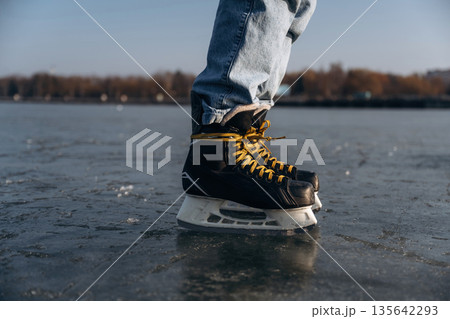 On the surface. Close up view of man that is on ice with skates in winter 135642293