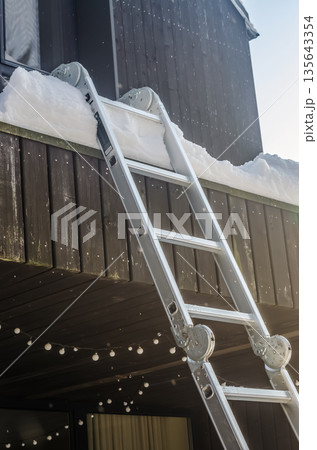 Winter Maintenance: Ladder Ready for Balcony Snow Removal. 135643354