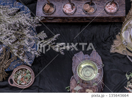 A Beautiful composition with a hot pandan leaf tea with indian marsh fleabane plant leaves and Safflower dried (Saffron substitute) at dark background. A Beautiful composition with a hot pandan leaf tea with indian marsh fleabane plant leaves and Safflower dried (Saffron substitute) at dark background. 135643664