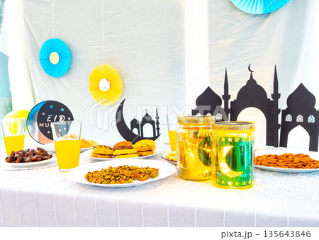 Eid Mubarak table with Ramadan sweets, dates, nuts and festive decor Eid Mubarak table with Ramadan sweets, dates, nuts and festive decor 135643846