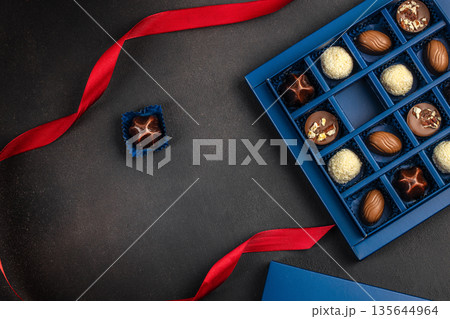Luxury chocolate pralines gift box with red ribbon and copy space Luxury chocolate pralines gift box with red ribbon and copy space 135644964