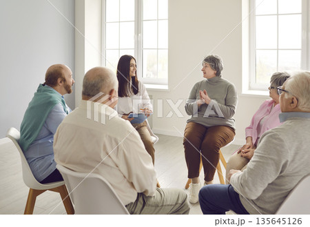 Several senior people sharing and discussing their problems at group therapy meeting 135645126