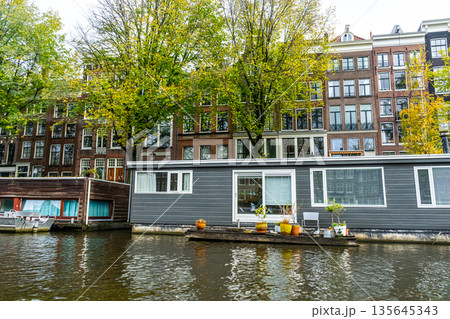 Amsterdam Canal with Houseboat and traditional house Building 135645343