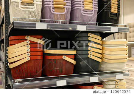Assorted stacked baskets with wooden handles in store display Assorted stacked baskets with wooden handles in store display 135645574